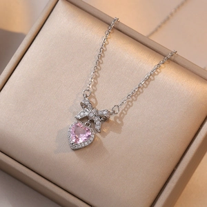 Collar con circón de corazón rosa y lazo plateado en una elegante caja de joyas