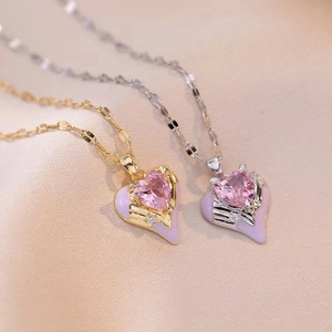 Close-up of heart pendant necklace with pink gem and lavender enamel on silk