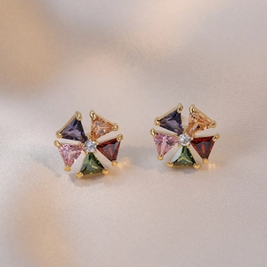 Vue détaillée de boucles d'oreilles en forme de moulin à vent avec zircons colorés