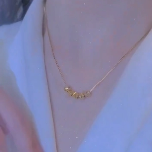 Elegante collana in titanio dorato da donna con cinque perle testurizzate su catena veneziana