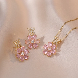 Elegantes rosa Blumen Schmuckset mit Halskette und Ohrringen auf Champagner Seide