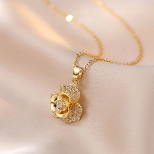 Elegant rotating rose gold flower pendant necklace with cubic zirconia on silk background