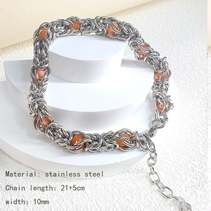 Industrial vintage stainless steel woven bracelet with orange beads on white display