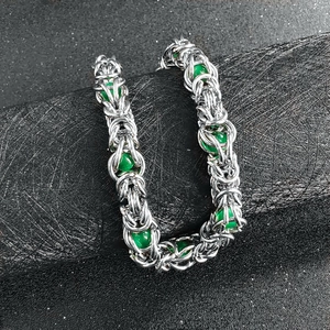 Detailed close-up of Byzantine style steel chain bracelet with green decorative beads