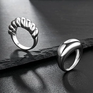 Minimalistisches Ring-Set aus Silber mit Kordel- und Kuppelform auf schwarzem Schiefer