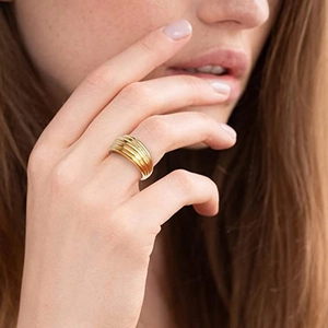 Detailansicht eines goldfarbenen Croissant-Rings im Dome-Stil an der Hand