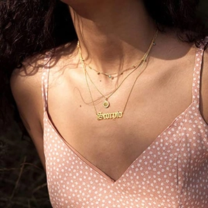 Vue détaillée de l'ensemble de colliers dorés Scorpio à trois rangs avec pendentif signe