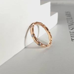 Detalle del anillo ondulado en oro rosa con cristales sobre soporte geométrico