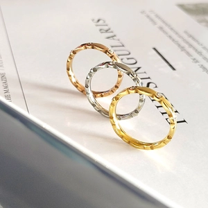 Detalle de tres anillos apilables en oro rosa, plata y oro con circonitas brillantes