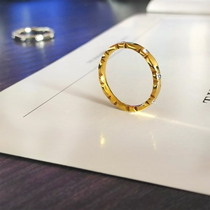 Vista macro detallada de un anillo de onda en oro rosa con textura facetada y circonitas