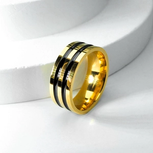 Gros plan sur la bague en acier titane doré avec rayures parallèles en émail noir