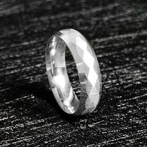 Detailopname van een 6mm facetgeslepen roestvrijstalen ring met geometrische reflecties