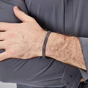 Close-up of men's dark grey stainless steel cuban chain bracelet on male wrist