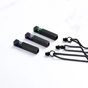 Detail of three black steel cylinder cremation pendants with blue purple and green crystals