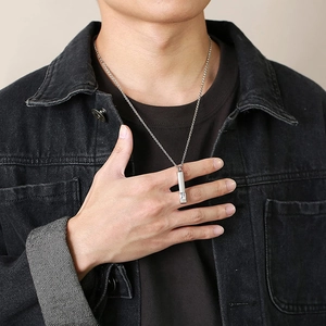 Close-up of minimalist silver bar urn necklace with a square clear gemstone on a male model