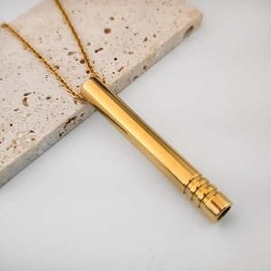 Collar de meditación en oro pulido con colgante cilíndrico sobre base de piedra moderna