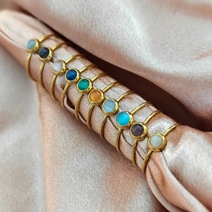 Dettaglio set di dieci anelli placcati oro 18K con varie pietre cabochon colorate vivaci