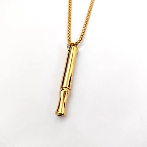 Primer plano de un colgante cilíndrico dorado para respiración con acabado pulido