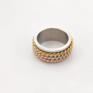 Detail eines mehrlagigen Spinner-Rings mit gold, silber und rosegold geflochtenen Bändern