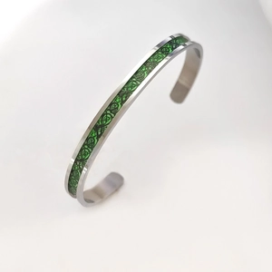 Close-up of stainless steel bangle with green luminous dragon scale pattern inlay