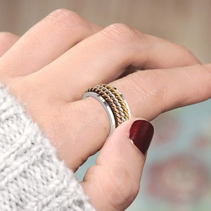 Nahaufnahme des dreifarbigen geflochtenen Spinner-Rings in Gold, Silber und Roségold