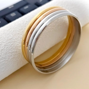 Brazalete minimalista de acero inoxidable pulido en tres tonos oro plata y oro rosa