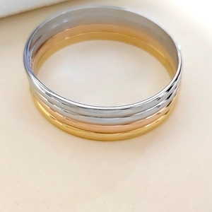 Pulsera trinity de acero inoxidable pulido con anillos entrelazados en tres tonos de metal