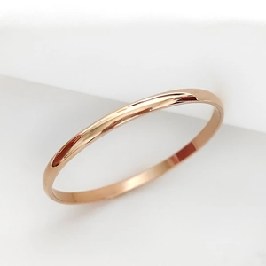 Primer plano de una pulsera minimalista de acero inoxidable oro rosa con acabado espejo pulido