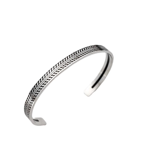 Dettaglio macro del bracciale rigido retrò con trama intrecciata e finitura ossidata