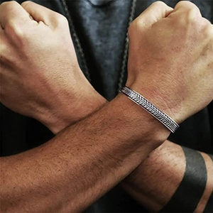 Dettaglio del bracciale rigido argento vintage con motivi a foglia sul polso uomo