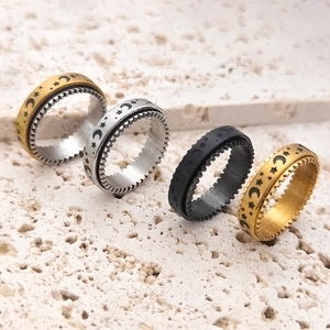 Close-up of rotating moon and star spinner rings with gear edges in gold and silver