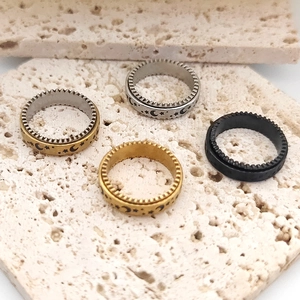 Detail showing spinner rings with engraved star and moon patterns on beige stone surface