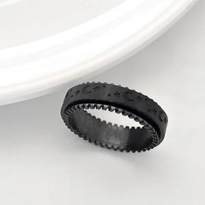 Close-up of black moon and star embossed spinning ring with gear edges for anxiety relief