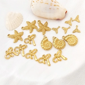 Set aus goldenen Titanstahl-Anhängern mit Seesternen, Muscheln, Schleifen und Walflossen