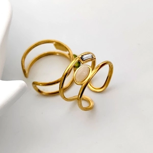 Macro detail of 18K gold stainless steel open ring with green zircon and oval stone