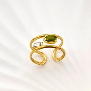 Detail view of double-layered gold ring with olive green zircon and matte metal texture