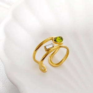 Detailed shot of gold-plated ring featuring green zircon and clear rectangular crystal