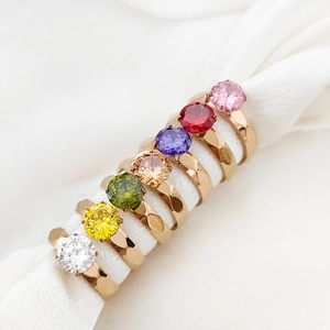 Set de siete anillos dorados con circonitas de colores y texturas geométricas elegantes