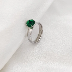 Detalle de una piedra de circón verde ovalada engastada en un anillo de acero inoxidable
