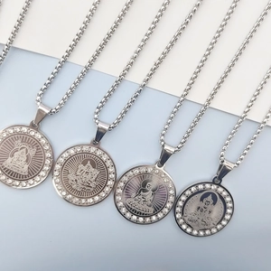 Macro detail of silver Buddha pendants with sparkling rhinestones and box chains