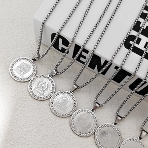 Detailed close-up of silver Buddha pendants with sparkling crystals on modern books