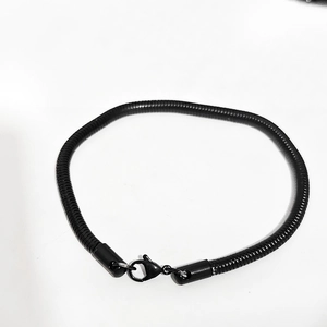 Détail de la gourmette noire en maille serpent avec fermoir mousqueton en métal