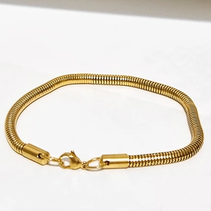 Gros plan du bracelet chaîne serpent doré avec fermoir mousqueton solide pour homme