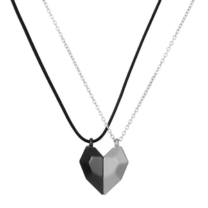 Magnetic heart pendant necklace set for couples with geometric facets on white background
