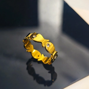 Gros plan sur une bague poisson en acier inoxydable doré avec des yeux en zircone