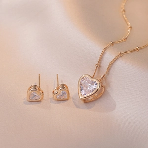 Elegante roségouden hartjes ketting en bijpassende oorknopjes set met heldere zirkonia steentjes