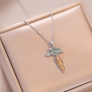 Detailed close-up of carrot pendant necklace with orange and green zircon stones