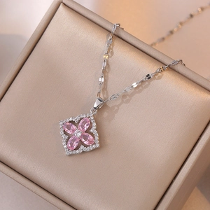 Close-up of sparkling pink zircon four-leaf flower pendant on silver-tone necklace