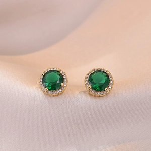 Boucles d'oreilles halo en zircon vert émeraude plaqué or sur fond de soie