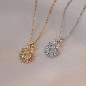 Détail de pendentifs fleur en zircone or et argent sur un tissu en soie élégant